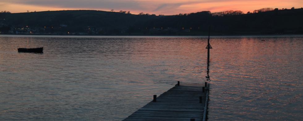 Ferryside Jetty after sunset with the lights of Llansteffan village